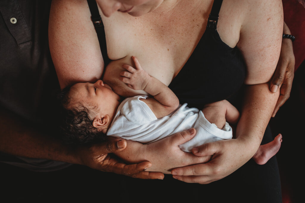 mother holding newborn baby breastfeeding
